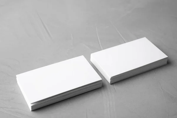 Blank business cards on light grey stone background. Mock up for design — ストック写真