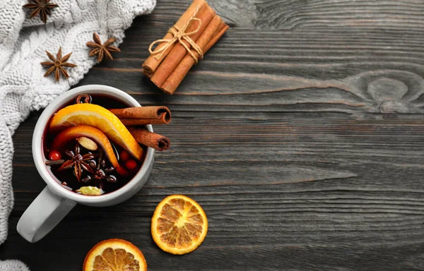 Copa de sabroso vino caliente en la mesa de madera negro, la puesta plana. Espacio para texto — Foto de Stock