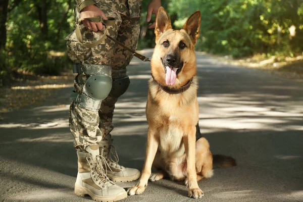 Hombre en uniforme militar con perro pastor alemán al aire libre, vista de cerca — Foto de Stock
