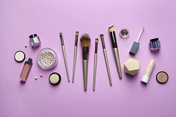 Flat lay composition with makeup brushes on lilac background
