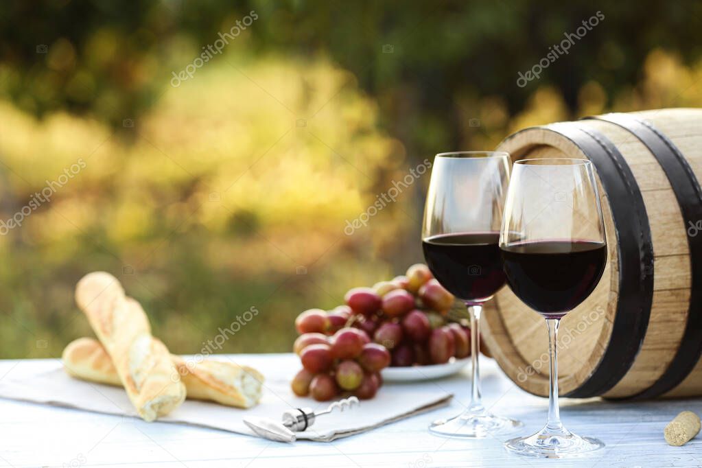 Composition with barrel of wine and products on table outdoors