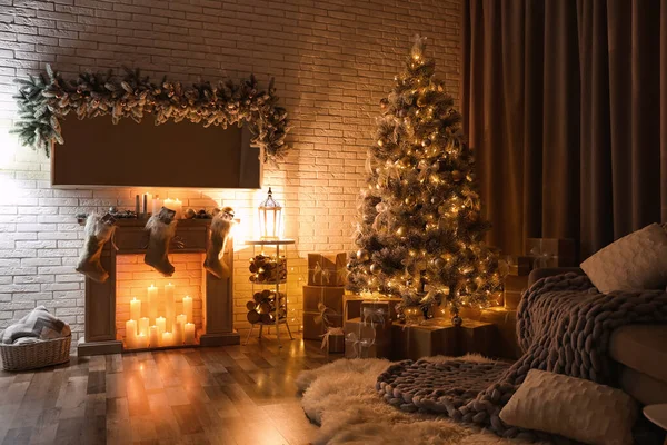 Elegante interior con hermoso árbol de Navidad y chimenea artificial por la noche — Foto de Stock