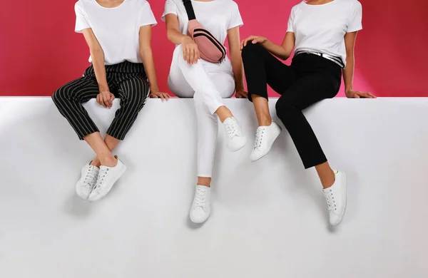 Las mujeres que usan zapatos elegantes en el fondo de color, primer plano — Foto de Stock