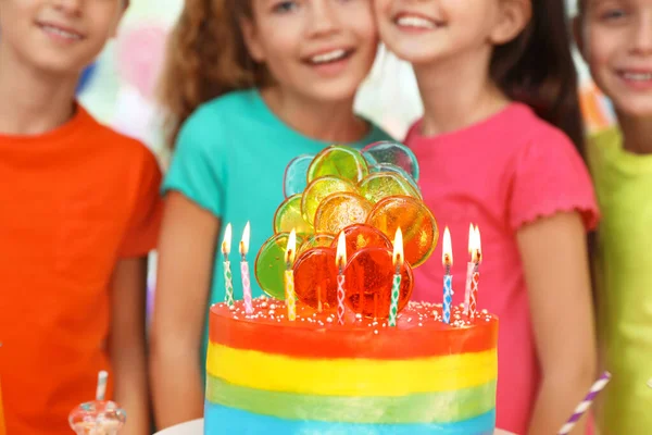 Los niños cerca de pastel con velas en la fiesta de cumpleaños en el interior, primer plano — Foto de Stock