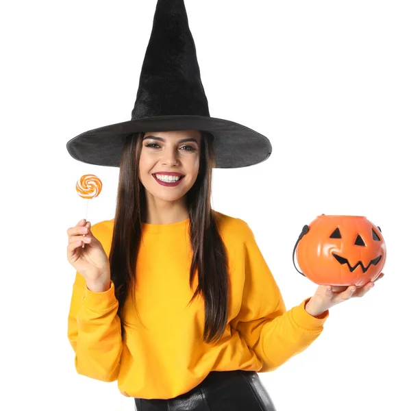 Mulher bonita vestindo traje de bruxa com Jack O 'Lantern recipiente de doces para festa de Halloween no fundo branco — Fotografia de Stock