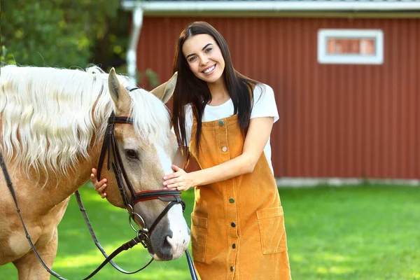 Palomino Pferd im Zaumzeug und junge Frau im Freien — Stockfoto