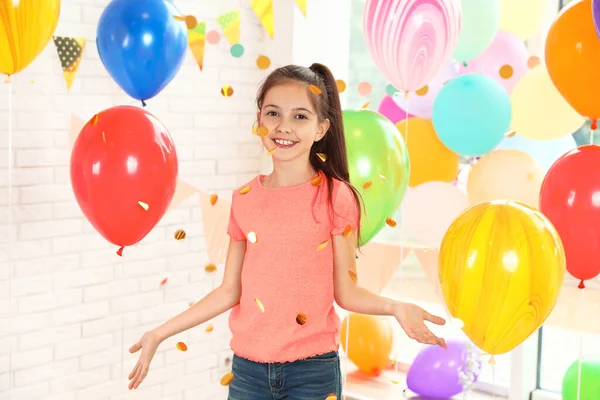 Boldog lány közelében fényes lufik születésnapi party beltérben — Stock Fotó