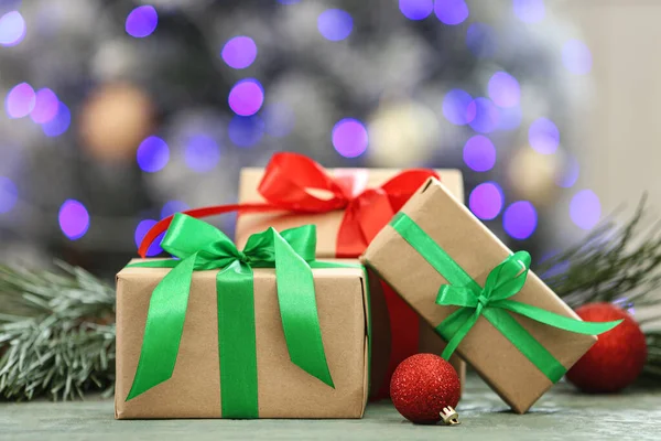 Presentes de Natal na mesa contra fundo desfocado — Fotografia de Stock