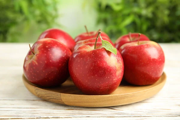 Fa lemez érett lédús vörös alma fehér asztalon ellen elmosódott háttér — Stock Fotó