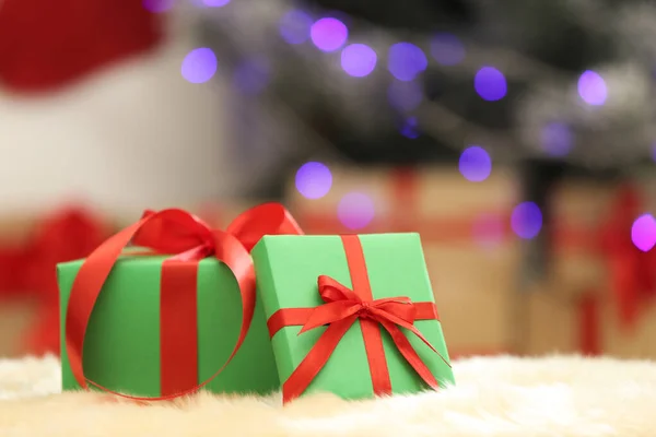 Рождественские подарки на нечетком ковре на размытом фоне, место для текста — стоковое фото