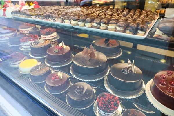 Různé lahodné dorty na displeji v kavárně, pohled oknem — Stock fotografie