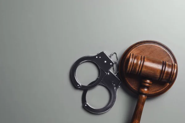 Judge's gavel and handcuffs on grey background, flat lay with space for text. Criminal law concept — Stock Photo, Image