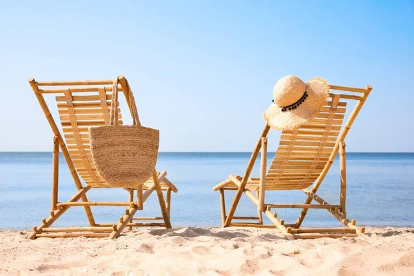 Cadeiras de madeira na praia de areia perto do mar — Fotografia de Stock