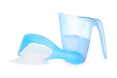 Beyaz arka plandaki plastik ölçü kaplarında çamaşır deterjanı