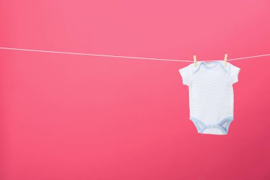 Bebek onesie pembe arka plan, metin için alan karşı giysi hattı üzerinde asılı