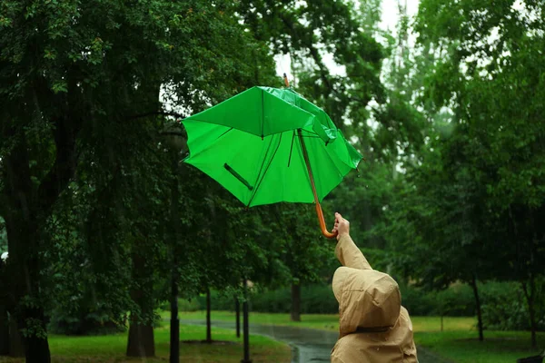 Frau mit kaputtem grünen Regenschirm an Regentag im Park — Stockfoto