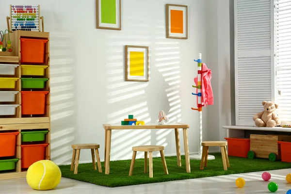 Elegante interior de la sala de juegos con mesa de madera y taburetes — Foto de Stock