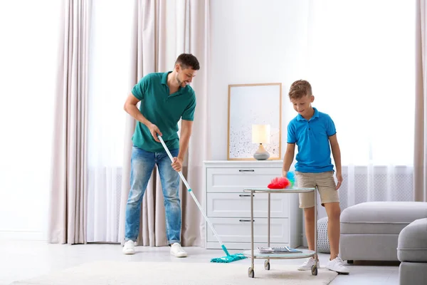 Papá e hijo limpiando la sala de estar juntos — Foto de Stock