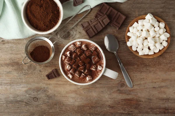 Komposition mit köstlichem heißen Kakaogetränk und Marshmallows auf Holzgrund, flache Lage — Stockfoto