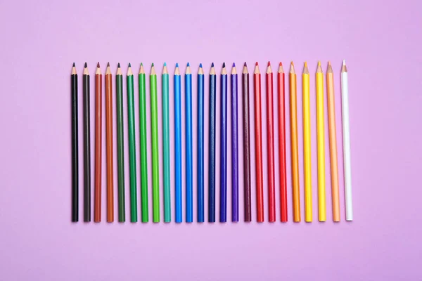 Crayons de couleur sur fond lilas, pose plate — Photo