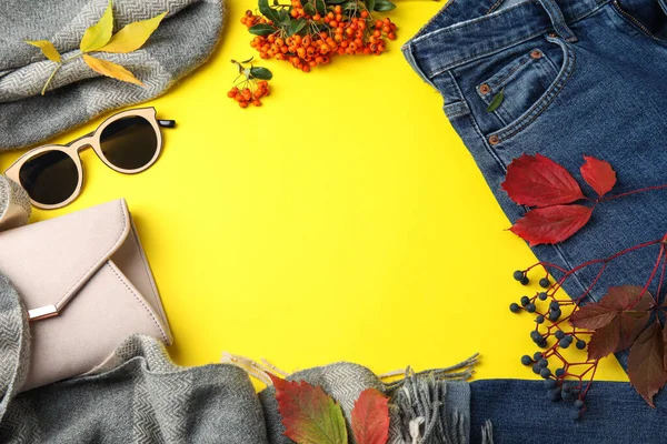 Flat lay composition with warm clothes and autumn leaves on yellow background, space for text — Stok fotoğraf