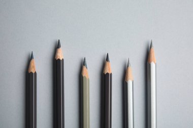 Gri arkaplanda renkli kalemlerle düz konum