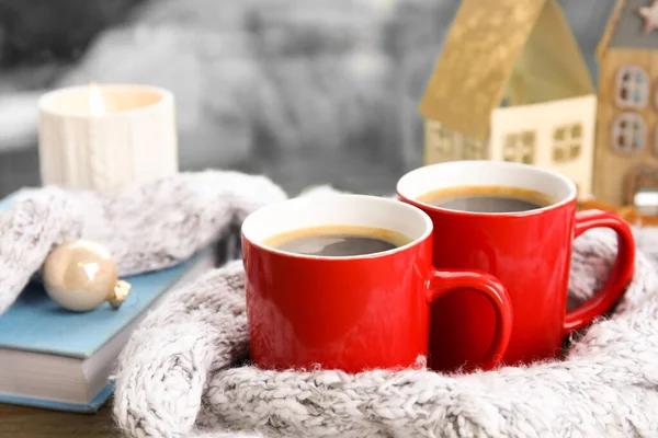 Kopjes warme winter drank met sjaal op vensterbank binnenshuis — Stockfoto