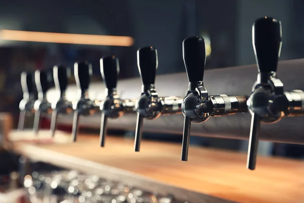 Row of shiny beer taps in pub, closeup — Stock Photo, Image