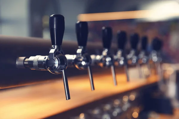 Row of shiny beer taps in pub — Stock Photo, Image