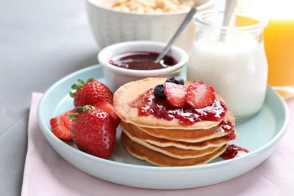 Crêpes fraîches avec confiture et fraises sur table gris clair. Petit déjeuner sain — Photo