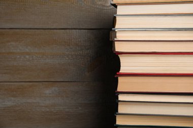 Ahşap arka planda bir yığın ciltli kitap. Metin için boşluk