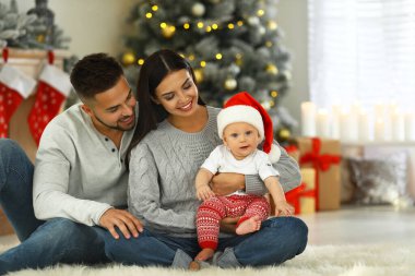 Evde şirin bir bebeği olan mutlu bir aile. Noel kutlaması