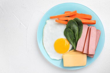 Sağlıklı kahvaltı tabağı, beyaz masa, üst manzara.