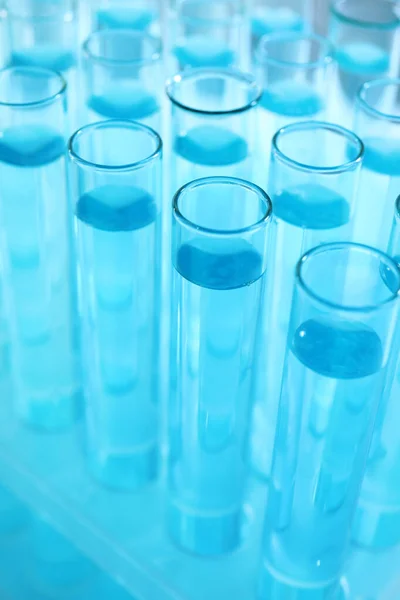 Muitos tubos de ensaio com líquido azul claro, close-up — Fotografia de Stock