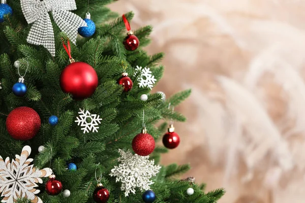 Schöner Weihnachtsbaum mit Dekor vor braunem Hintergrund. Raum für Text — Stockfoto