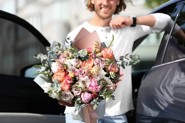 Hombre con hermoso ramo de flores cerca de coche en la calle, primer plano — Foto de Stock