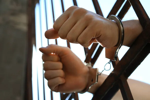 Hombre esposado en la cárcel al aire libre, vista de bajo ángulo. Derecho penal — Foto de Stock