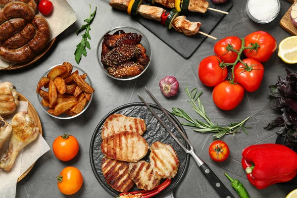 Lapos feküdt kompozíció grillezett hússal és zöldséggel, szürke asztalon — Stock Fotó