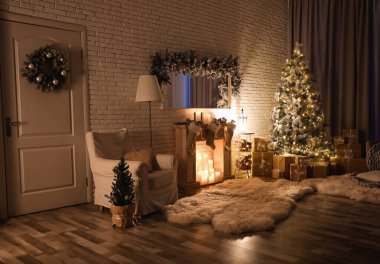 Stylish interior with beautiful Christmas tree and artificial fireplace at night clipart