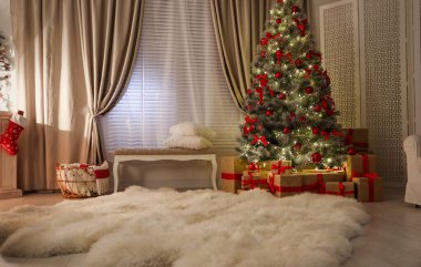 Dekore edilmiş Noel ağacı olan oturma odasının içinde.