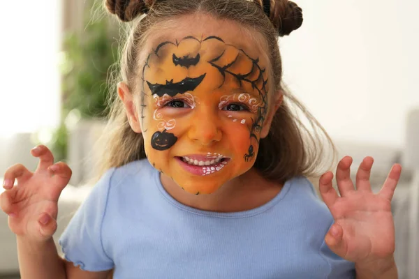 Menina bonito com pintura de rosto dentro de casa — Fotografia de Stock