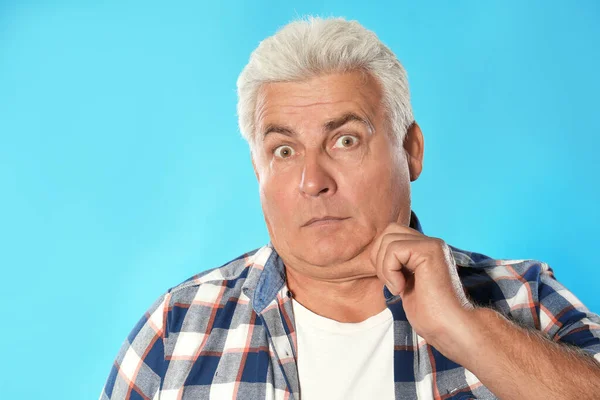 Emotional mature man with double chin on blue background — Stock Photo, Image