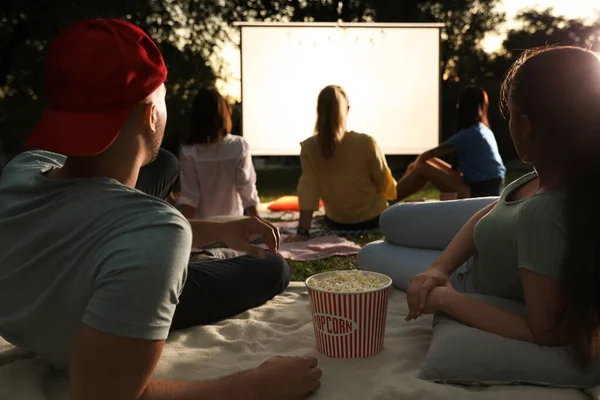 Młoda para z popcorn oglądania filmu w kinie na otwartym powietrzu. Miejsce na tekst — Zdjęcie stockowe