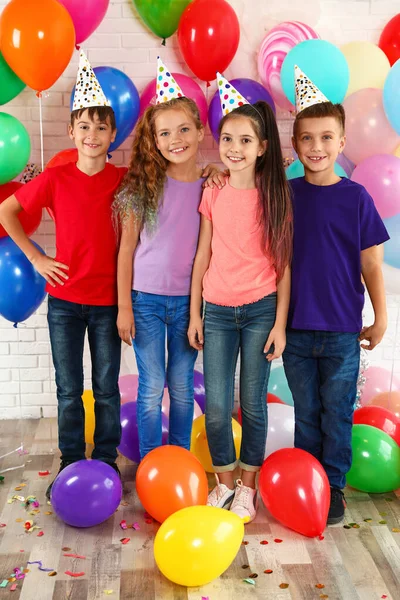 Ευτυχισμένα παιδιά κοντά σε φωτεινά μπαλόνια στο πάρτι γενεθλίων σε εσωτερικούς χώρους — Φωτογραφία Αρχείου