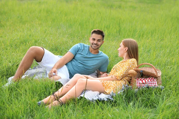 Boldog fiatal pár piknik zöld fű a parkban — Stock Fotó