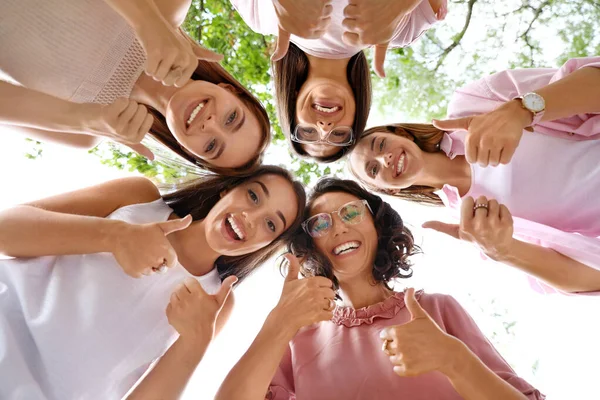 Mujeres felices mostrando pulgares al aire libre, vista inferior. concepto de poder chica — Foto de Stock