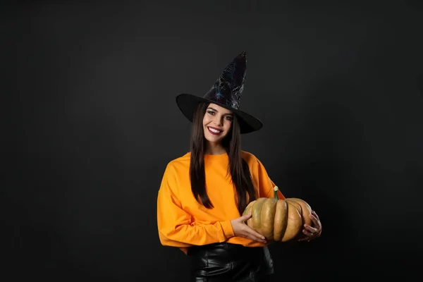 Beautiful woman wearing witch costume with pumpkin for Halloween party on black background — Stock Photo, Image
