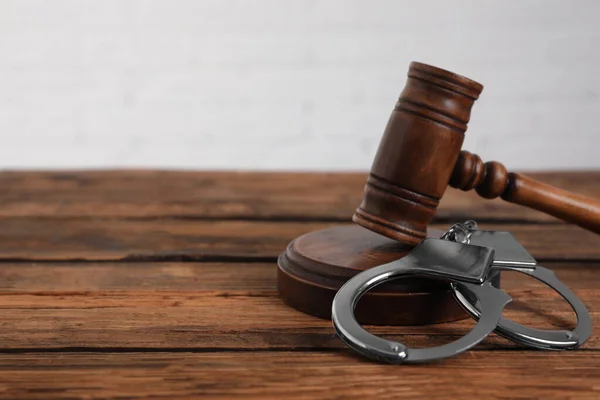 Гевель і наручники на дерев'яному столі, місце для тексту. Кримінальне право — стокове фото