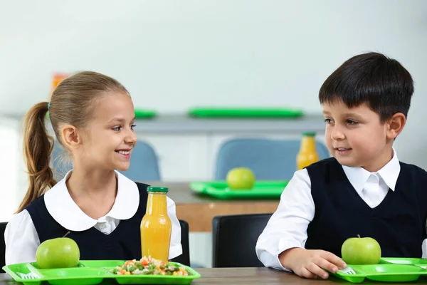 Crianças felizes comendo comida saudável para o almoço na cantina da escola — Fotografia de Stock