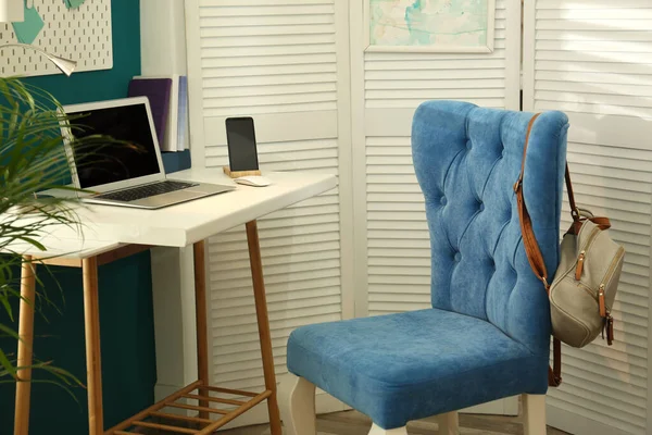 Stylish home workplace with elegant blue chair. Interior design